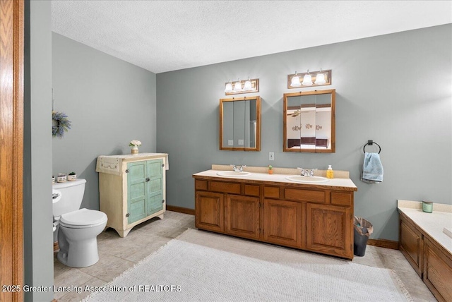 4582 N Watson Rd, Elsie, MI 48831 - bathroom with double vanity, toilet, a textured ceiling, and baseboards