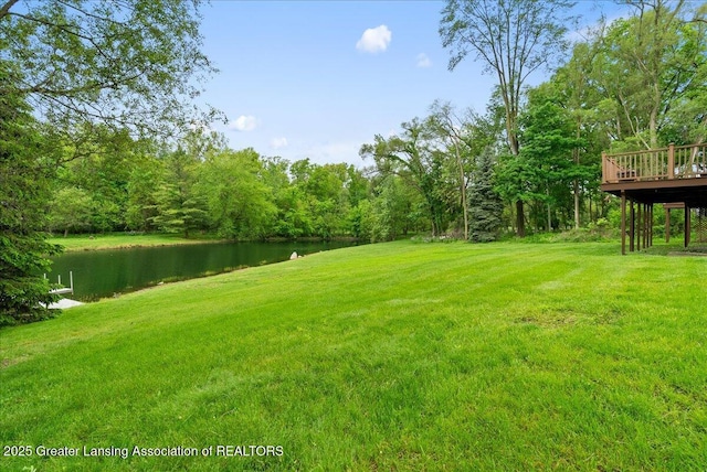 4582 N Watson Rd, Elsie, MI 48831 - view of green lawn featuring a deck with water view and a view of trees