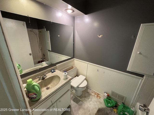 3425 Cooley Dr, Lansing, MI 48911 - full bathroom featuring toilet, vanity, a wainscoted wall, and shower / tub combination