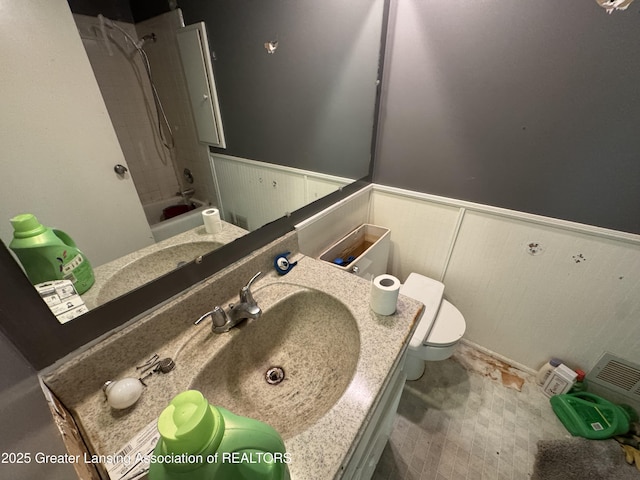 3425 Cooley Dr, Lansing, MI 48911 - full bathroom with wainscoting, toilet, bathtub / shower combination, and vanity