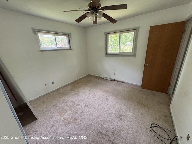 3425 Cooley Dr, Lansing, MI 48911 - unfurnished bedroom with multiple windows, carpet floors, and a ceiling fan