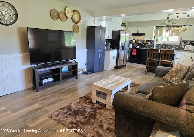 3066 S Canfield Rd, Eaton Rapids, MI 48827 - living room with light wood finished floors and a wainscoted wall