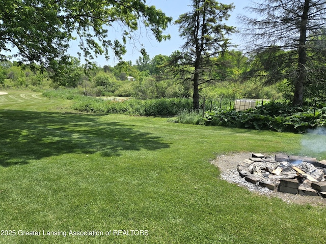 3066 S Canfield Rd, Eaton Rapids, MI 48827 - view of green lawn featuring a fire pit