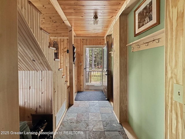2623 Timberlane Trl, Grayling, MI 49738 - entryway featuring stone tile floors, wooden ceiling, wood walls, and baseboards