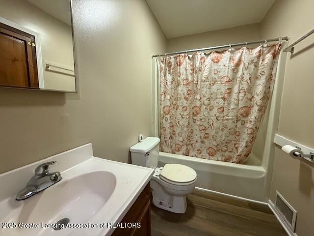 207 Wight St Unit 209, Elsie, MI 48831 - bathroom with wood finished floors, vanity, shower / tub combo with curtain, and toilet