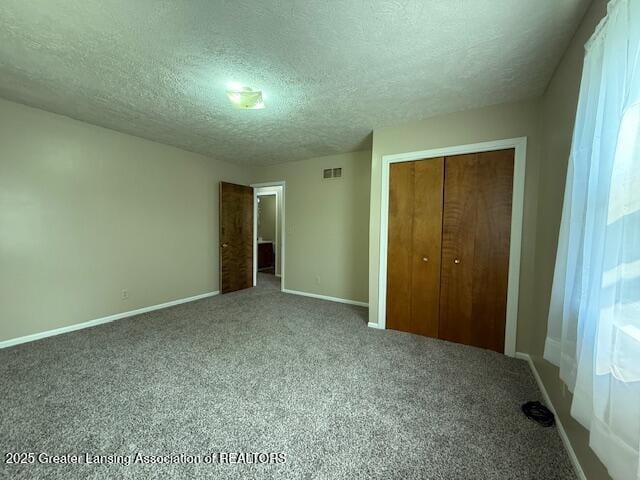 207 Wight St Unit 209, Elsie, MI 48831 - unfurnished bedroom featuring a textured ceiling, a closet, baseboards, and carpet