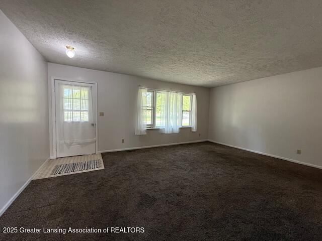 207 Wight St Unit 209, Elsie, MI 48831 - foyer featuring a textured ceiling, carpet flooring, and baseboards