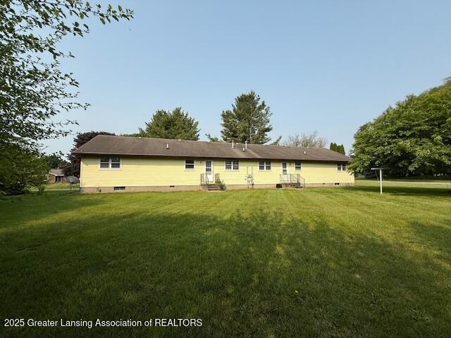 207 Wight St Unit 209, Elsie, MI 48831 - back of property with a lawn and crawl space