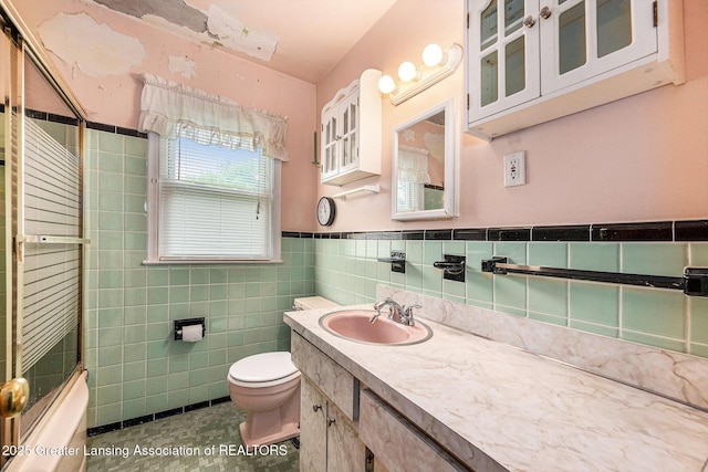 18762 Woodland St, Harper Woods, MI 48225 - full bath with vanity, toilet, tile walls, enclosed tub / shower combo, and wainscoting