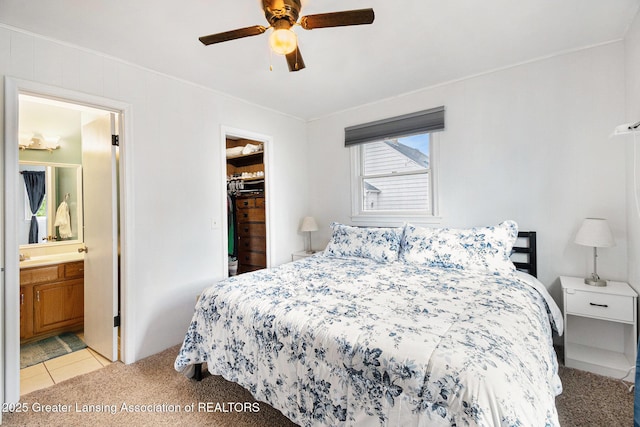 4415 Devonshire Ave, Lansing, MI 48910 - bedroom with crown molding, light colored carpet, a spacious closet, connected bathroom, and ceiling fan