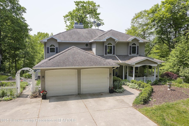 11781 W Herbison Rd, Eagle, MI 48822 - view of front of home with concrete driveway, an attached garage, a porch, a shingled roof, and a chimney