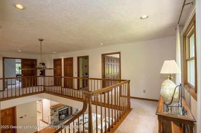 11781 W Herbison Rd, Eagle, MI 48822 - corridor featuring an upstairs landing, carpet, baseboards, a textured ceiling, and recessed lighting
