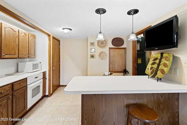 11781 W Herbison Rd, Eagle, MI 48822 - kitchen with white appliances, a peninsula, a kitchen breakfast bar, decorative light fixtures, and light tile patterned flooring