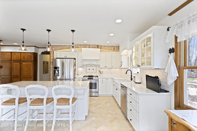 11781 W Herbison Rd, Eagle, MI 48822 - kitchen with appliances with stainless steel finishes, custom exhaust hood, healthy amount of natural light, glass insert cabinets, and recessed lighting
