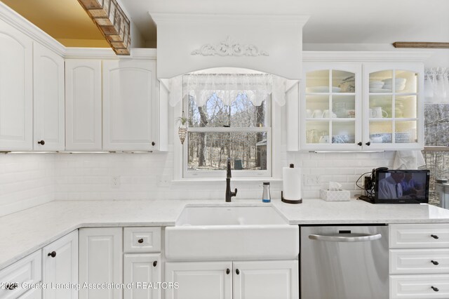 11781 W Herbison Rd, Eagle, MI 48822 - kitchen with stainless steel dishwasher, a sink, decorative backsplash, glass insert cabinets, and white cabinetry