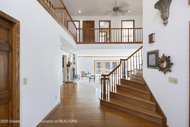 11781 W Herbison Rd, Eagle, MI 48822 - foyer entrance with a ceiling fan, wood finished floors, stairway, a high ceiling, and recessed lighting