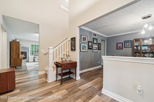 1058 Buckingham Rd, Haslett, MI 48840 - hallway featuring wood finished floors, stairway, baseboards, and ornamental molding