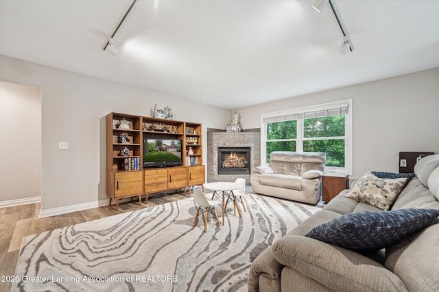 1058 Buckingham Rd, Haslett, MI 48840 - living area featuring rail lighting, wood finished floors, baseboards, and a tile fireplace