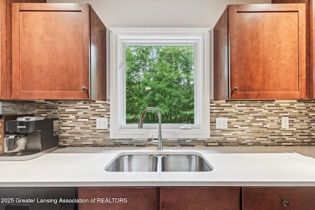1058 Buckingham Rd, Haslett, MI 48840 - kitchen featuring a sink, light countertops, and backsplash