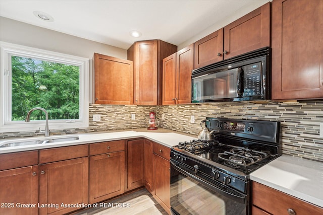 1058 Buckingham Rd, Haslett, MI 48840 - kitchen featuring black appliances, a sink, light countertops, and backsplash