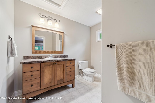 1058 Buckingham Rd, Haslett, MI 48840 - bathroom featuring vanity, toilet, baseboards, and tile patterned flooring