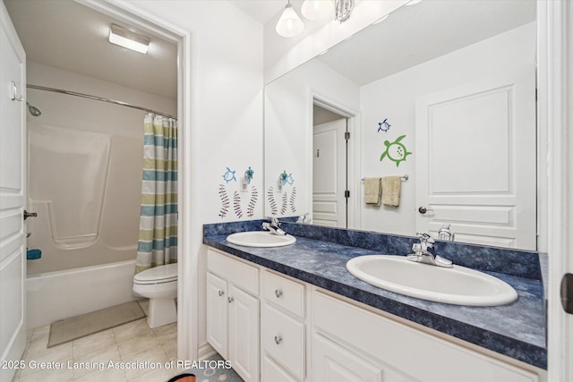 1058 Buckingham Rd, Haslett, MI 48840 - full bath featuring double vanity, toilet, tile patterned floors, and shower / tub combo