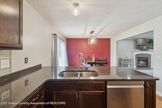 2705 Tapestry Dr Unit 53, Okemos, MI 48864 - kitchen featuring dishwasher, a sink, a peninsula, dark brown cabinetry, and dark stone countertops