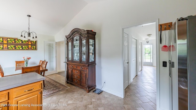 1100 Cranbrook Ln, Mason, MI 48854 - dining space with lofted ceiling, a chandelier, baseboards, and stone finish flooring