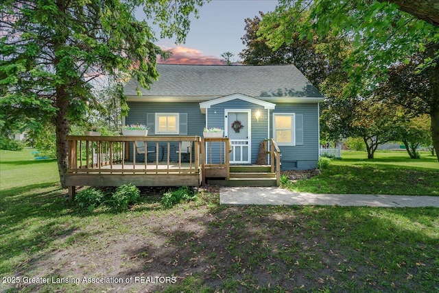 424 N Morrice Rd, Morrice, MI 48857 - view of front of home featuring a front lawn, a wooden deck, and a shingled roof