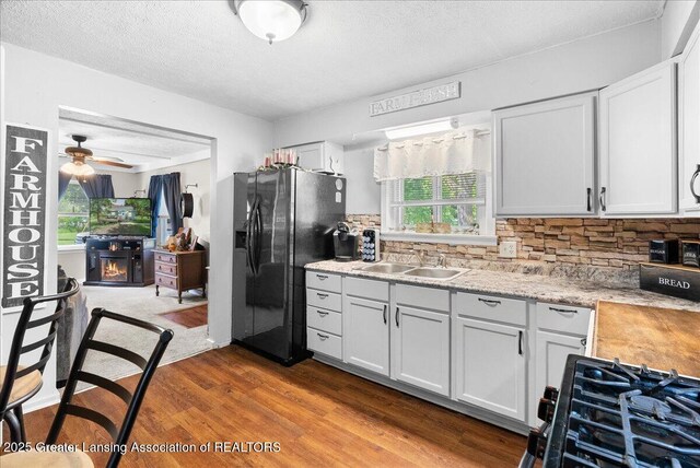 424 N Morrice Rd, Morrice, MI 48857 - kitchen with black appliances, a sink, light countertops, dark wood-type flooring, and a textured ceiling