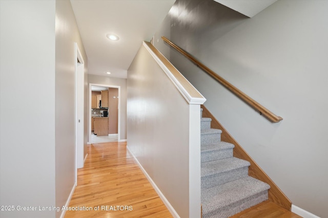 5619 Bittern Dr, Holt, MI 48842 - staircase with wood finished floors, recessed lighting, and baseboards