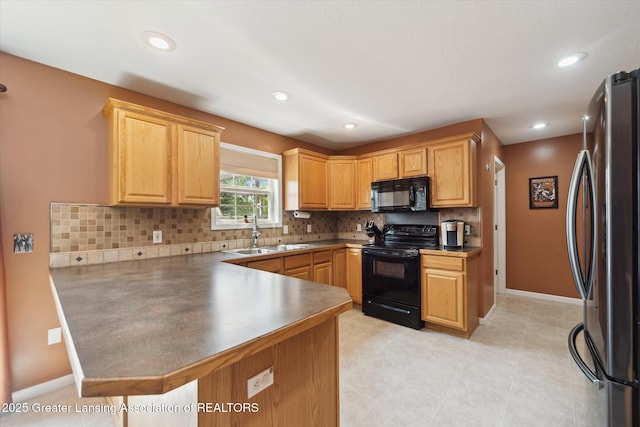5619 Bittern Dr, Holt, MI 48842 - kitchen featuring black appliances, a sink, a peninsula, backsplash, and baseboards