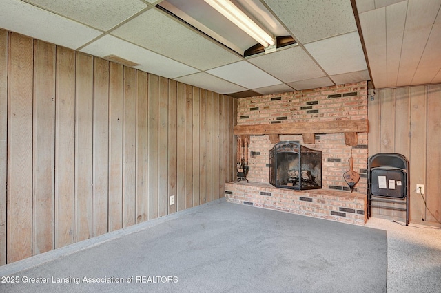14311 Chandler Rd, Bath, MI 48808 - unfurnished living room featuring a paneled ceiling, wood walls, carpet floors, and a fireplace