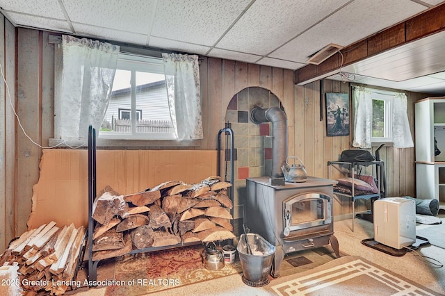 14311 Chandler Rd, Bath, MI 48808 - detailed view of a wood stove, wood walls, and a paneled ceiling