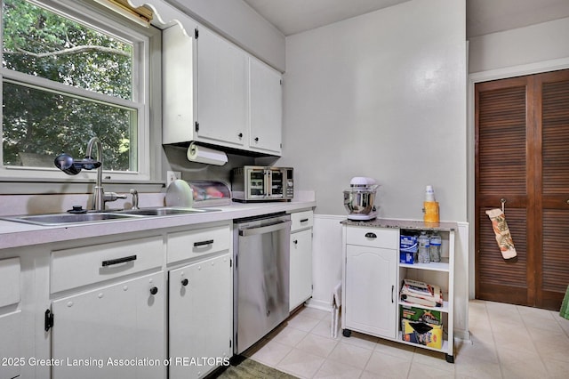 14311 Chandler Rd, Bath, MI 48808 - kitchen with stainless steel dishwasher, light countertops, white cabinetry, and light tile patterned flooring