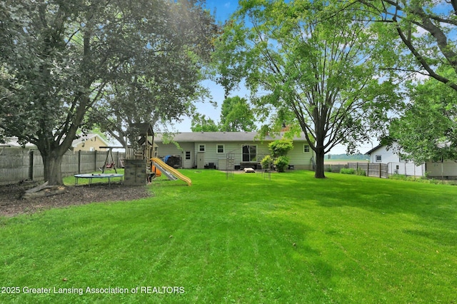 14311 Chandler Rd, Bath, MI 48808 - view of yard with a playground and a trampoline