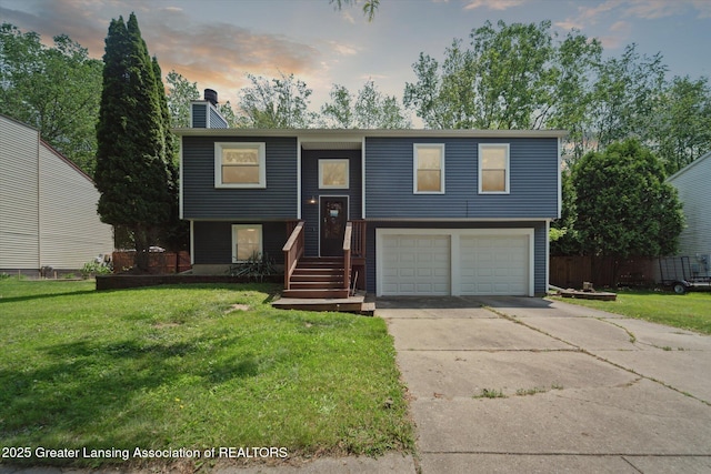 2500 Champion Way, Lansing, MI 48910 - bi-level home featuring an attached garage, concrete driveway, a lawn, and a chimney