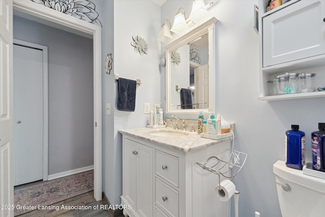 2500 Champion Way, Lansing, MI 48910 - bathroom featuring toilet, vanity, wood finished floors, and baseboards