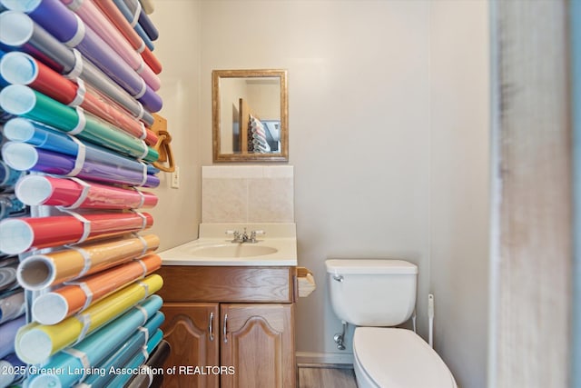 2500 Champion Way, Lansing, MI 48910 - half bath with toilet, vanity, and decorative backsplash