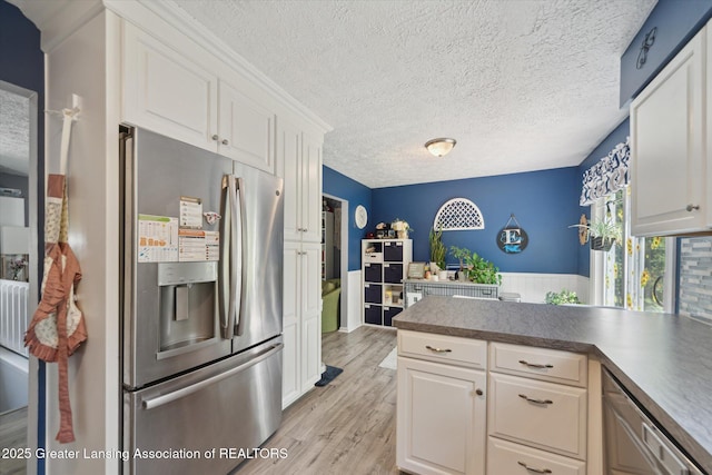 2500 Champion Way, Lansing, MI 48910 - kitchen with stainless steel appliances, light wood finished floors, a peninsula, white cabinets, and a textured ceiling