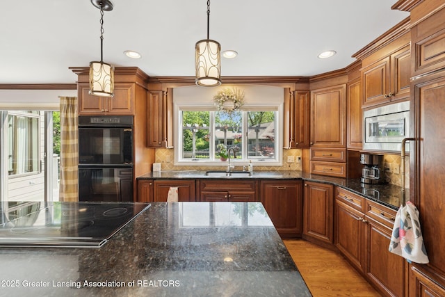1209 Windale Pl, East Lansing, MI 48823 - kitchen with a sink, black appliances, brown cabinetry, tasteful backsplash, and recessed lighting