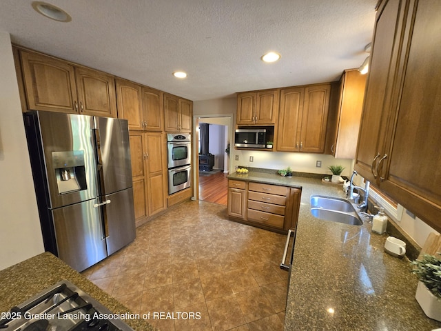 4423 Hyatt St, Eaton Rapids, MI 48827 - kitchen with stainless steel appliances, a sink, brown cabinets, recessed lighting, and dark stone counters