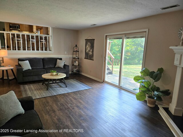 4423 Hyatt St, Eaton Rapids, MI 48827 - living room featuring a textured ceiling, wood finished floors, and baseboards