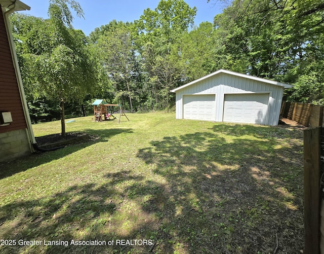 4423 Hyatt St, Eaton Rapids, MI 48827 - view of yard featuring a playground, a garage, and an outbuilding