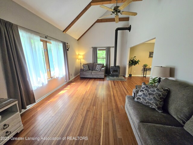 4423 Hyatt St, Eaton Rapids, MI 48827 - living area featuring high vaulted ceiling, a wood stove, a ceiling fan, beamed ceiling, and wood-type flooring