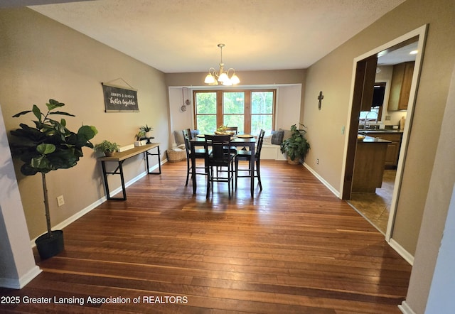 4423 Hyatt St, Eaton Rapids, MI 48827 - dining space featuring a chandelier, dark wood finished floors, and baseboards