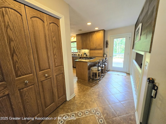4423 Hyatt St, Eaton Rapids, MI 48827 - kitchen featuring brown cabinets, healthy amount of natural light, stainless steel appliances, recessed lighting, and light tile patterned floors