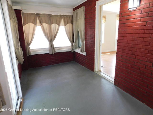 1305 May St, Lansing, MI 48906 - empty room with finished concrete floors and brick wall