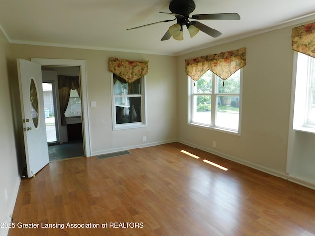 1305 May St, Lansing, MI 48906 - unfurnished room with crown molding, wood finished floors, ceiling fan, and baseboards