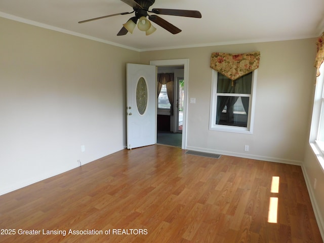 1305 May St, Lansing, MI 48906 - unfurnished room with light wood-style floors, ceiling fan, ornamental molding, and baseboards